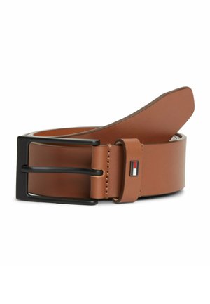 Cintura in pelle marrone con fibbia in metallo nero e piccolo logo rettangolare rosso, bianco e blu navy sull'anello della cintura, arrotolata su sfondo bianco.