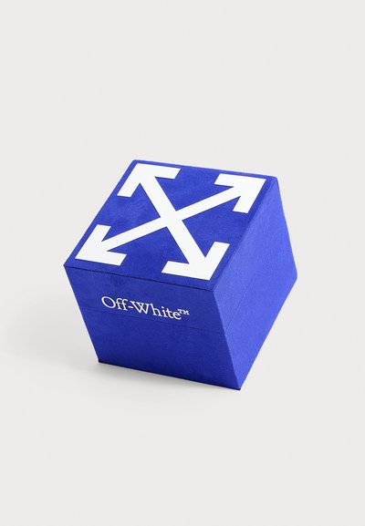 Boîte bleue en forme de cube avec des flèches blanches croisées sur le dessus et le nom de la marque Off-White imprimé sur le côté en texte blanc.