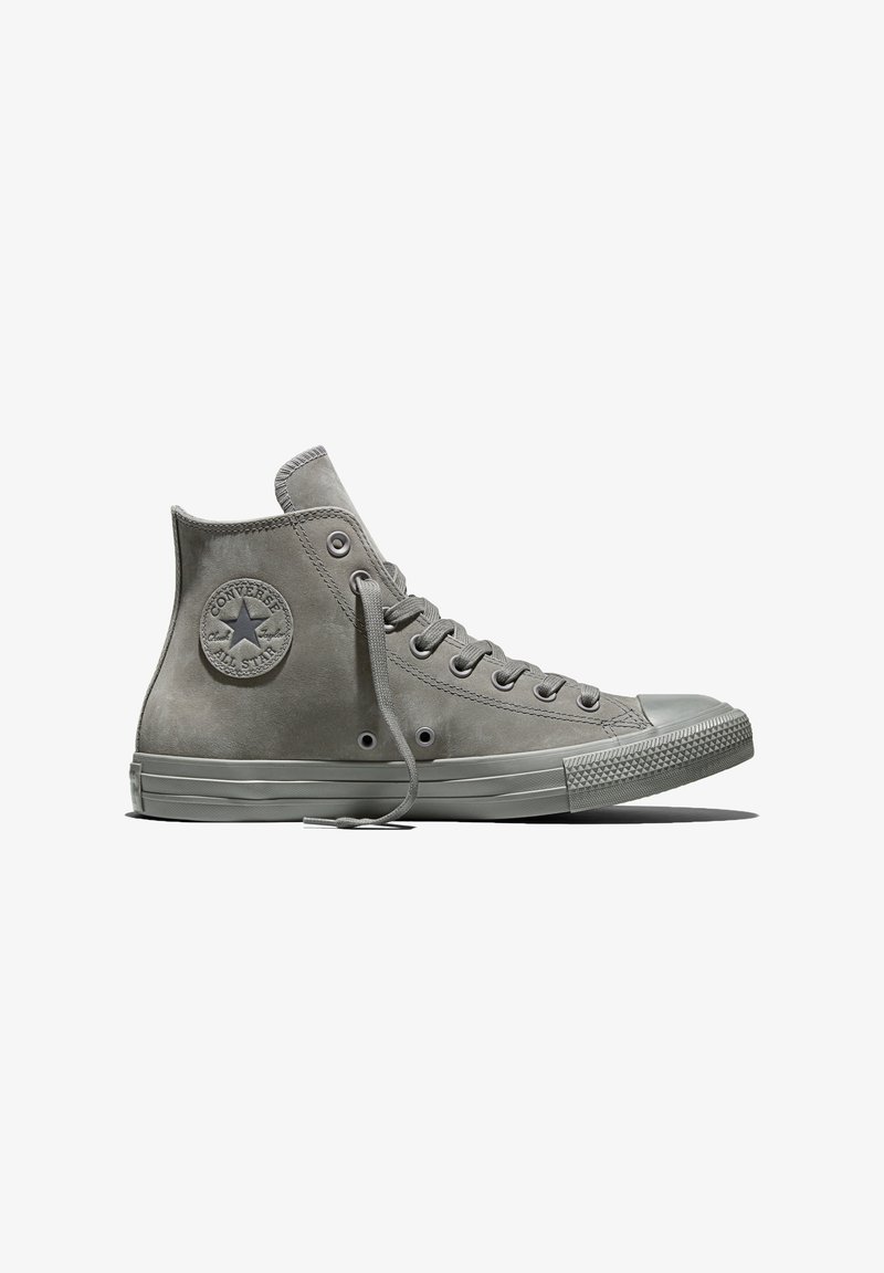 Grijze hoge Converse All Star sneaker met veters en een rubberen zool, gezien van de zijkant op een witte achtergrond.