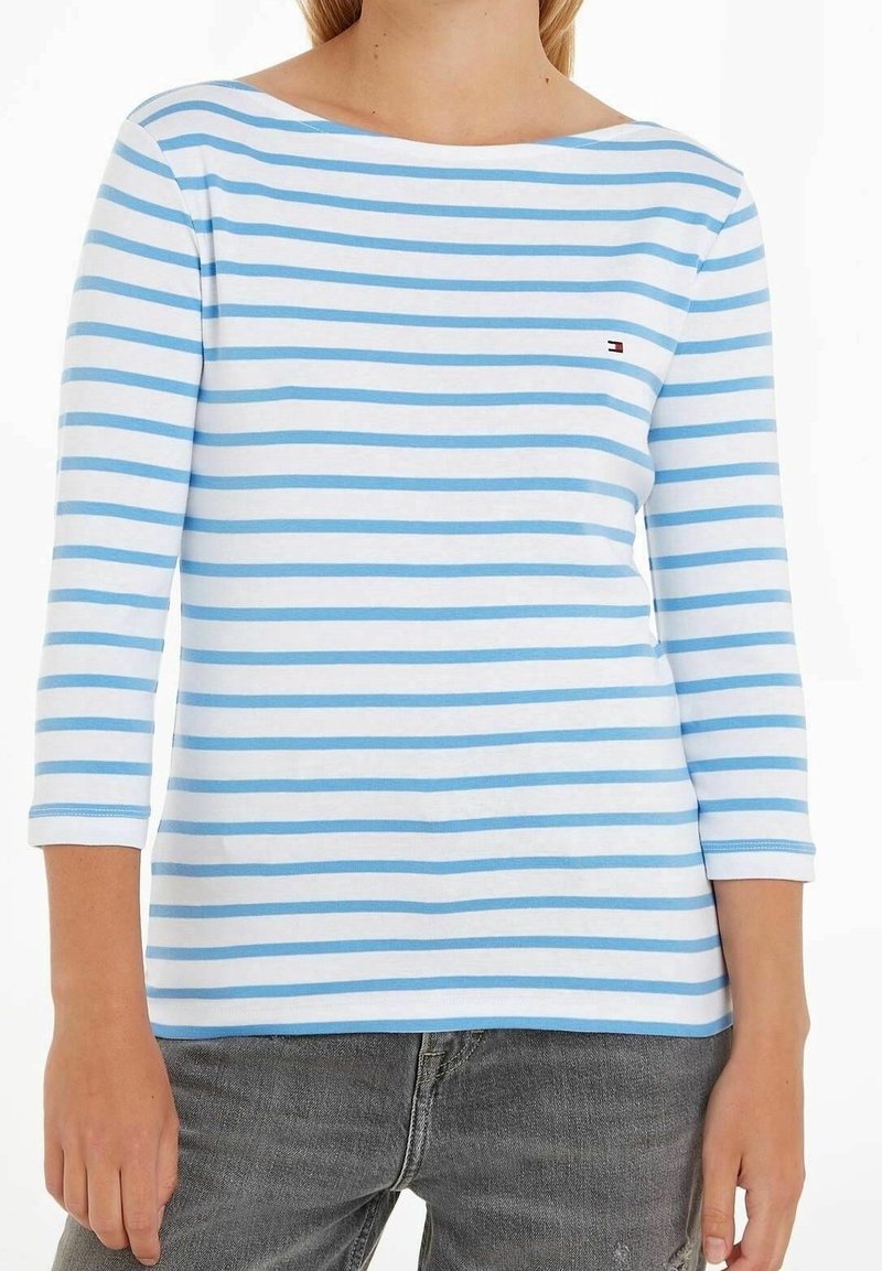 Camisa de manga larga a rayas en azul claro y blanco. Cuenta con un escote amplio y un logo en el pecho. Material de algodón suave con un ajuste regular.