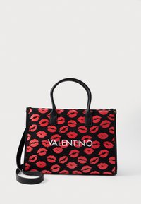 Black tote bag with red lip print, featuring two black handles and a removable shoulder strap. Prominent white "VALENTINO" logo on front.