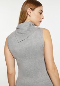 Maglione grigio senza maniche con colletto alto a costine. Tessuto morbido e testurizzato con spalle senza cuciture e una silhouette aderente.