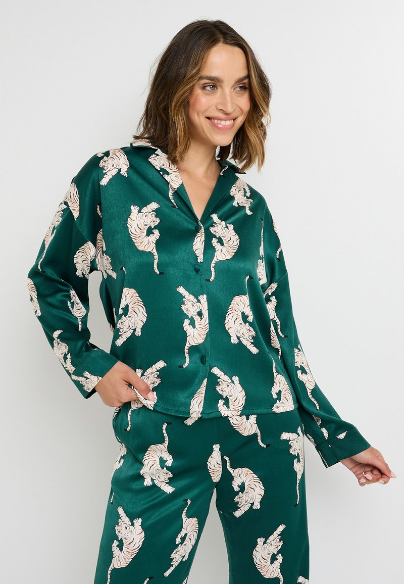 Set di pigiama in satin verde composto da una camicia con bottoni e pantaloni, decorato con illustrazioni di tigri dai colori chiari. Texture liscia con una vestibilità comoda.