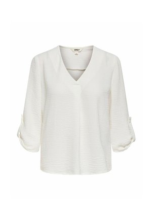 Blouse blanche texturée à manches longues avec col en V et manches retroussables maintenues par des pattes à boutons.