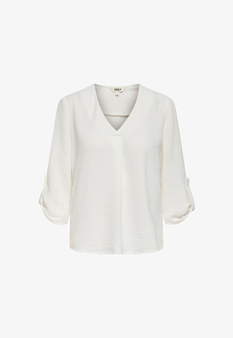 Blouse blanche texturée à manches longues avec col en V et manches retroussables maintenues par des pattes à boutons.