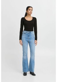 Black long-sleeve bodysuit paired with light blue flared jeans and black ankle boots. The jeans feature a high waist and subtle whiskering.
