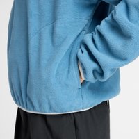 Pulover din fleece de culoare albastru deschis, cu un material texturat, talie elastică și buzunare laterale. Designul are mâneci lungi cu tivuri împăcurate.