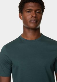 Donkerblauwe korte mouwen t-shirt gemaakt van een zachte, gladde stof. Heeft een ronde hals en een normale pasvorm, zonder zichtbare patronen of accenten.