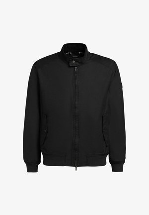 Zwarte jas met ritssluiting en opstaande kraag, twee klepzakken met knopen aan de voorkant en geribde manchetten en boord.