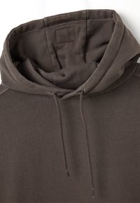 Felpa marrone con cappuccio, caratterizzata da un cordino, una texture liscia e una tasca a marsupio. Il tessuto presenta una leggera costina attorno all' neckline e all'orlo.