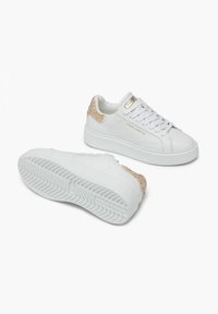 Sneakers bianchi con accenti dorati e un tallone beige testurizzato. Parte superiore in pelle liscia, punta tonda e suola in gomma spessa con battistrada a disegno.