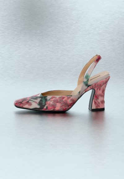 Ροζ παπούτσι slingback με λουλούδια, τακούνι τύπου block και μυτερή μύτη, σε ανοιχτό γκρι φόντο.