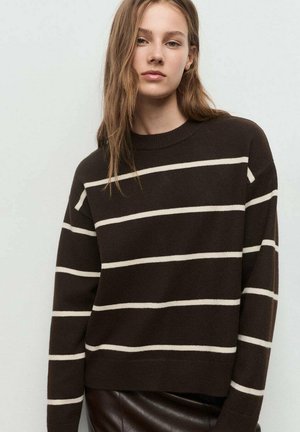 Suéter marrón a rayas con rayas blancas horizontales, cuello redondo y mangas largas. Tejido suave, corte relajado, diseño corto.