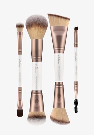 Ensemble de cinq pinceaux de maquillage avec des manches blancs et des accents en or rose. Diverses formes comprennent un pinceau poudre rond, un pinceau contour plat et un pinceau à sourcils anglé.