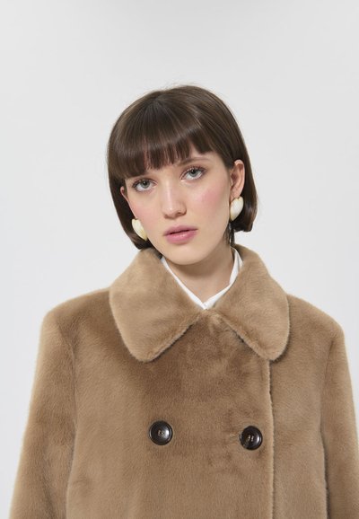 Cappotto in pelliccia sintetica marrone con ampio colletto, design doppiopetto e bottoni neri. Texture liscia e aspetto morbido.