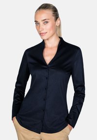 Navy Hemd mit Mandarin-Kragen, glatter Textur und langen Ärmeln. Verfügt über dunkle Knöpfe und eine taillierte Passform.