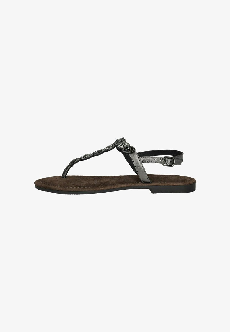 Sandalias planas de tiras en negro, con una correa trenzada y acentos metálicos. Plantilla marrón suave con superficie texturizada, correa ajustable en el tobillo.