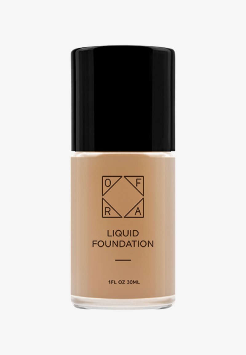 Fondotinta liquido beige in una bottiglia di vetro trasparente con un tappo in plastica nera. Presenta un'etichetta minimalista con il nome del marchio e i dettagli del prodotto.
