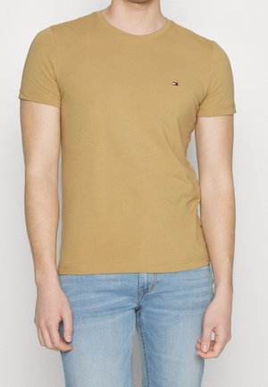 Short-sleeve T-shirt made of soft cotton in a mustard color with a small embroidered logo on the chest. Plain design, crew neck.