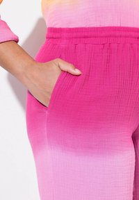 Roze ombre broek van een textuurachtige, lichtgewicht stof, met een elastische tailleband en een zijzak.