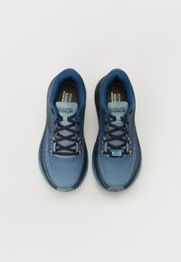 Zapatillas deportivas azules con parte superior de malla transpirable, cuello acolchado, suela texturizada y acentos naranjas. Presentan un diseño flexible para mayor comodidad.