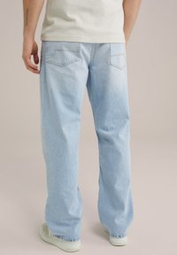Lichtblauwe denim jeans met een relaxte pasvorm, voorzien van achterzakken en subtiele stikseldetails. Glad textuur, licht vervaagde afwerking.
