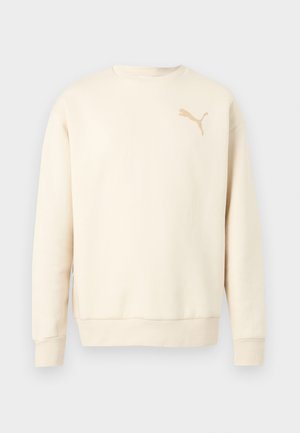 Kremkrāsas garroku sporta krekls ar apaļu kakla izgriezumu, ar ribotām aprocēm un apakšmalu, kreisajā krūtīs neliela brūngani pelēka Puma logotips.