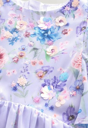 Violets audums ar ziedu rakstu rozā, zilā un zaļā krāsā; papildināts ar aplikācijām no fliteriem un vairākslāņu ziedu motīviem. Mīksts, teksturēts virsmas apdare.