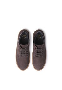 Scarpe in suede marrone con lacci, punta tonda e suola in gomma tan a contrasto, caratterizzate da una morbida fodera interna nera e una marchiatura dorata.
