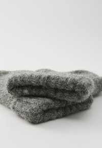 Gray woolen fabric, textured and fluffy, folded neatly. The material has a soft, fuzzy appearance with visible fibers and light shading.
