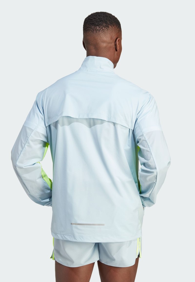 Helle blaue Jacke mit grünen Akzenten. Mit langen Ärmeln, hohem Kragen und einem reflektierenden Streifen am Saum. Leichtes, aerodynamisches Design.