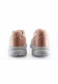 Ljusrosa sneakers med ett slätt material, rundad design, vadderad krage och vita gummisulor; har logotyp på hälen.