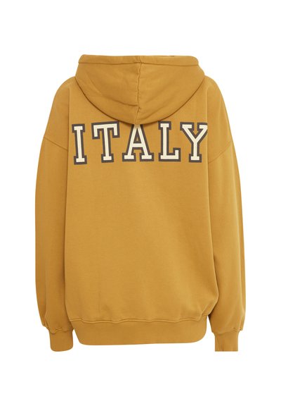Dzeltenais kapuces džemperis piedāvā brīvu piegriezumu un ribotas rokas. Mugurā ir redzami lieli, masīvi burti ar kontrastējošām kontūrām, kas raksta "ITĀLIJA".