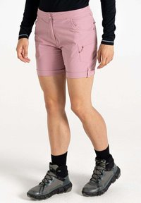 Helle rosa Shorts mit einem figurbetonten Design, ausgestattet mit einer Seitentasche und umgeschlagenen Säumen, kombiniert mit grauen Wanderschuhen und schwarzen Socken.