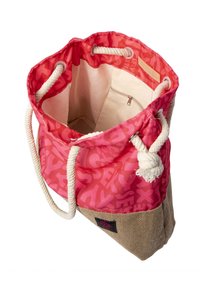 Offene rosa und beige Tragetasche mit Seilgriffen, innerer Reißverschlusstasche und abstraktem Buchstabenmuster auf dem Stoffäußeren.