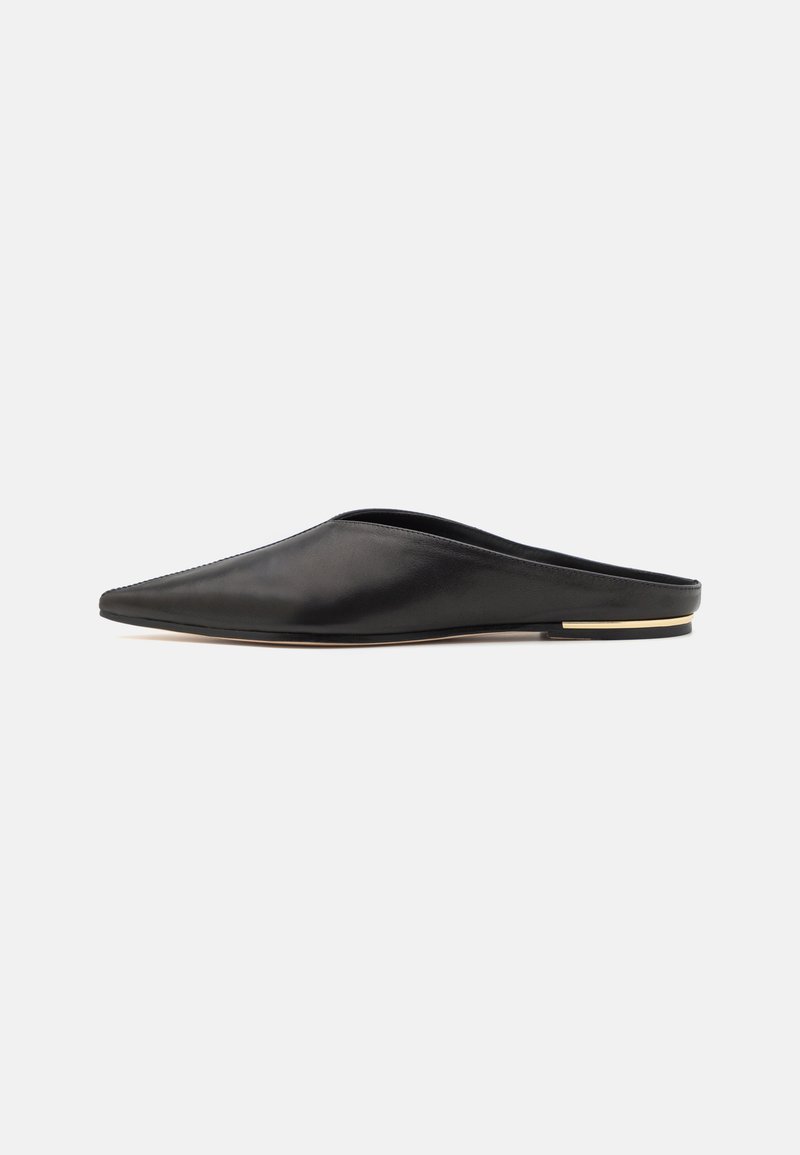 Svarte skinn slip-on sko med spiss tå, minimalistisk design, glatt tekstur og et gullaccent på den flate sålen.