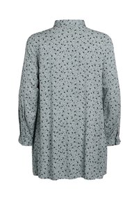 Long-sleeve shirt in a light green fabric, featuring a floral pattern, buttoned cuff, and a classic collar, with a relaxed fit and longer back.