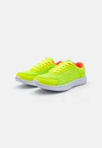 Neon gule atletiske sko med en tekstureret mesh-overdel, hvid sål og livlige orange detaljer på indersiden og snørebåndene.