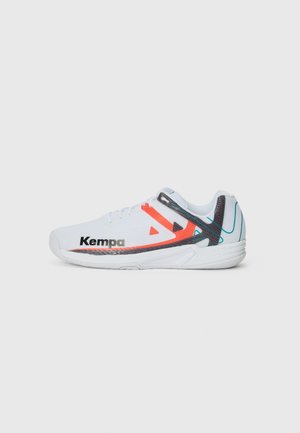 Chaussure de sport blanche avec une tige en maille, accents orange et noir, et logo "Kempa". Présente une semelle texturée et un design qui offre un bon soutien.
