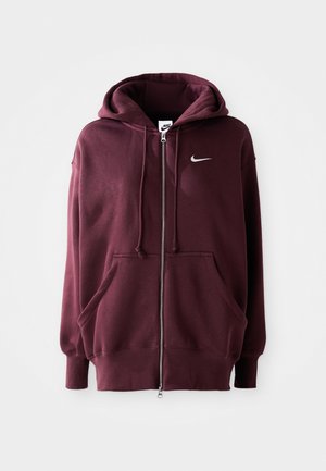 Burgundi Nike kapucnis pulóver elülső cipzárral, nagy kapucnival, elülső zsebekkel és egy apró fehér logóval a bal mellen. Puha anyag ribbed ujjal.