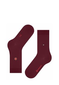 Bordowe skarpetki z zielonym i czerwonym wzorem gwiazdy w okolicy kostki oraz małym logo wydrukowanym na boku w kolorze czerwonym, ułożone płasko.