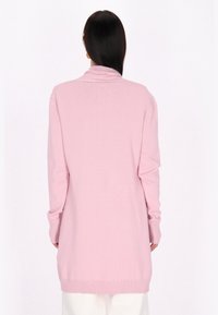 Långärmad rosa cardigan i stickad material med sjalkrage, ribbade ärmslut och nederkant; baksidan visar en rak skärning och slät textur.