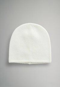 Biała dzianinowa czapka z zaokrągloną koroną i prążkowanym mankietem. Materiał wydaje się miękki z delikatną fakturą, odpowiedni na zimną pogodę.