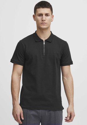 Černé polo tričko vyrobené z bavlněné směsi, s límcem na zip a krátkými rukávy. Obsahuje decentní logo na hrudi.