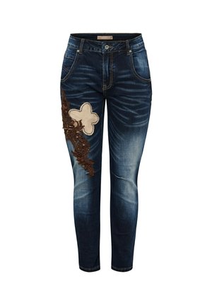 Mørkeblå denim jeans med falmet effekt, med en stor beige blomstermærke og brun blomst broderi på venstre lår.