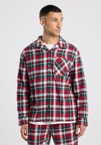 Gestreept overhemd van zachte flanel, met rode, groene en witte patronen. Opvallende details zijn een borstzak en knoopsluiting.