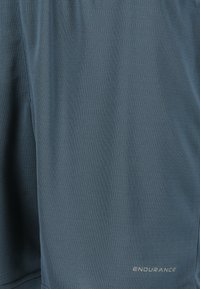 Miestne športové šortky vyrobené z ľahkého tkaného materiálu v slate modrej farbe. Obsahujú jemnú textúru a logo "ENDURANCE" blízko spodného lemu.