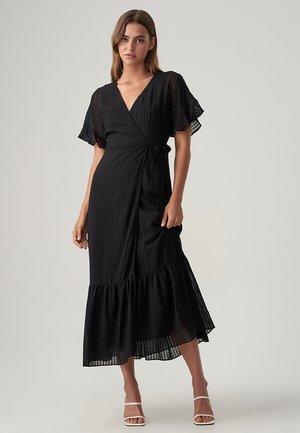 Vestido negro ajustado con mangas cortas y rizadas, un patrón a rayas y un dobladillo en vuelo. Presenta un lazo en la cintura para un ajuste ajustable.
