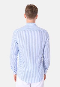 Camicia a maniche lunghe a righe blu chiaro e bianche con colletto standard e polsini abbottonati, orlo curvo e tessuto testurizzato.