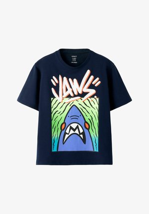 Marineblå T-skjorte med en stor grafikk av en åpenmuntet blå hai og ordet "JAWS" i fete, stiliserte oransje bokstaver over.